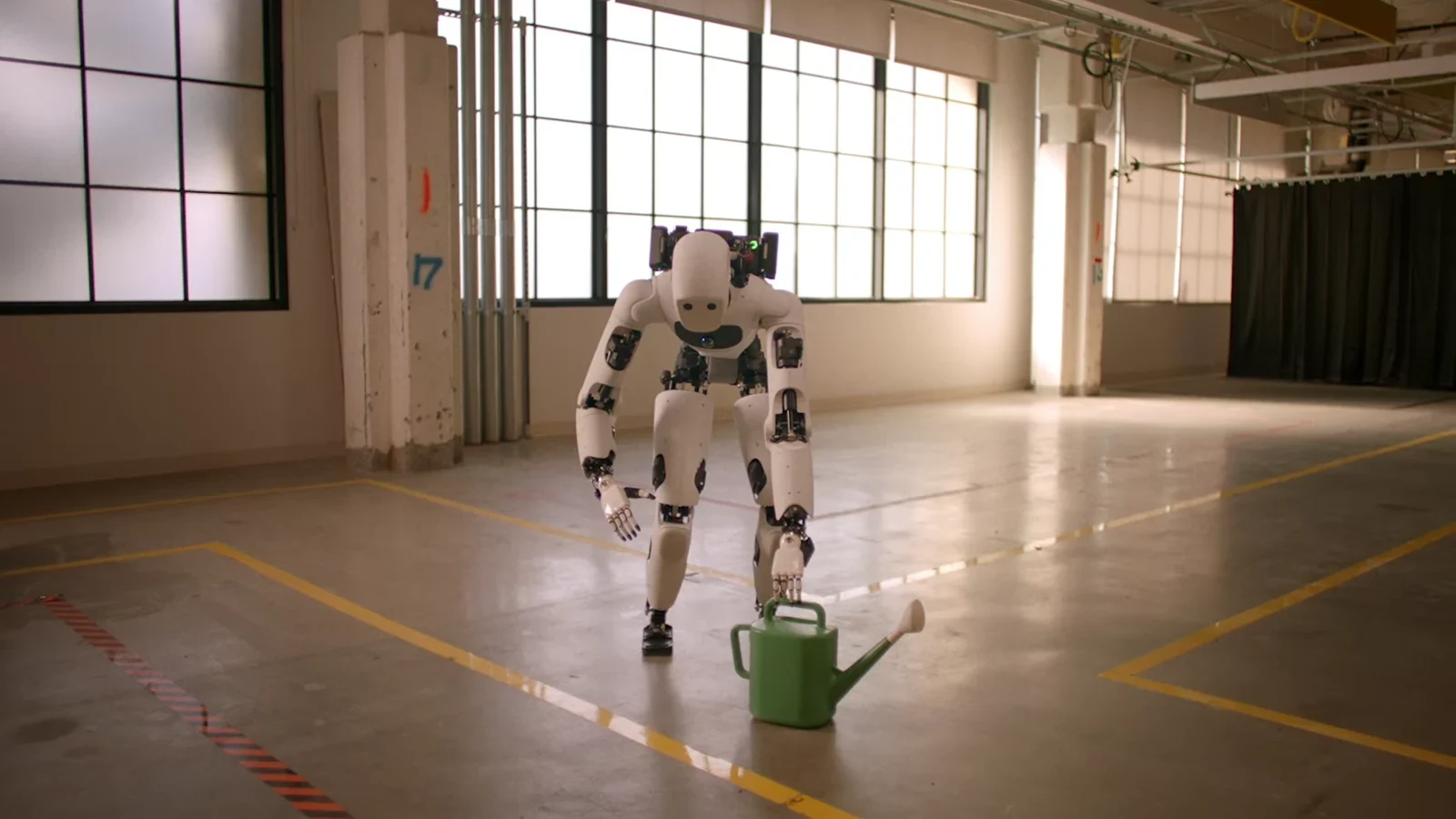 A humanoid reaching for a watering can in Google DeepMind's Gemini Robotics 2 demonstration